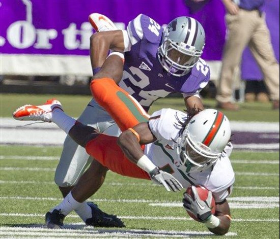 Miami wide receiver Allen Hurns (1) is tackled by Kansas State defensive back Nigel Malone (24) during the first half of an NCAA football game in...