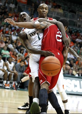 North Carolina State's Lorenzo Brown (2) runs into Miami's Durand Scott (1) after Scott passed the ball during the first half. (AP Photo/The News...