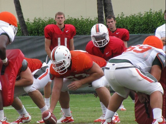 Ryan Williams and Spencer Whipple watch as senior Jacory Harris takes the snap from Tyler Horn.