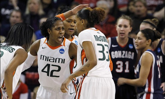 Miami's Shenise Johnson (42) tries to fire up her teammates as Gonzaga players huddle behind them in the first half of an NCAA tournament second-round...