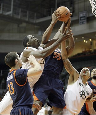 Miami's Dwayne Collins, left,  and Julian Gamble, right, fight Virginia's Jerome Meyinsse (55)for a loose ball  during an NCAA college basketball game...