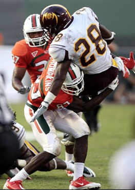 Bethune-Cookman's Angelo Cabrera (28) is taken down by Miami's Kendal Thompkins (83) in the second half of an NCAA college football game in Miami,...