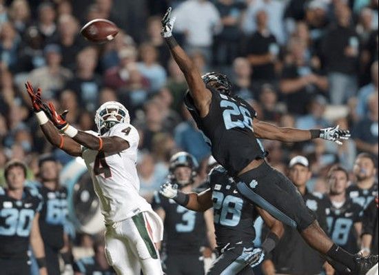 Miami's Phillip Dorsett (4) reaches for a pass as North Carolina's Dominique Green (26) defends during the first half of an NCAA college football game...