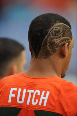 niversity of Miami Hurricanes linebacker Jordan Futch #58 on the sidelines with Sebastian the Ibis cut into his hair in a game against the University...