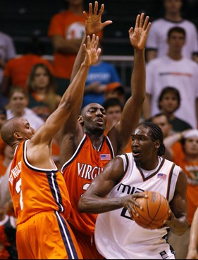 Miami forward Dwayne Collins, right, looks for an open teammate past Virginia guard J.R. Reynolds, left, and center Tunji Soroye during the second...