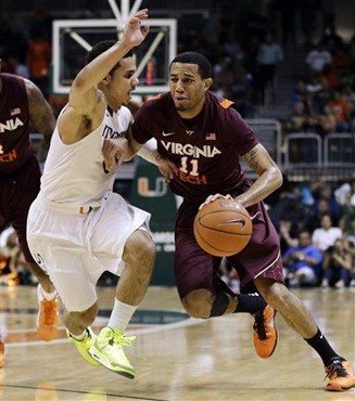 Miami's Shane Larkin (0) tries to steal the ball from Virginia Tech's Erick Green (11) during the first half of an NCAA college basketball game in...