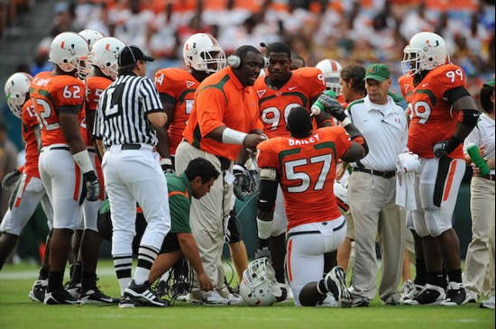 University of Miami Hurricanes defensive line coach Clint Hurtt discusses a call with defensive end Allen Bailey #57 and the defense in a game against...