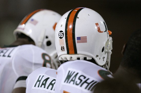 Miami defensive end Courtney Harris, center, watches the field wearing a sticker with the number 95 on it during the second half of their football...