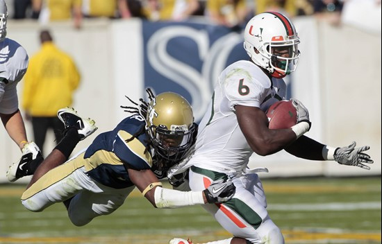 Miami running back Lamar Miller (6) is dragged down by Georgia Tech cornerback Mario Butler (2) in the third quarter of an NCAA college football game...