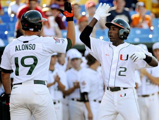 Miami's Jemile Weeks (2) is greeted by teammate Yonder Alonso after Weeks hit a home run in the first inning against Georgia in an NCAA College World...