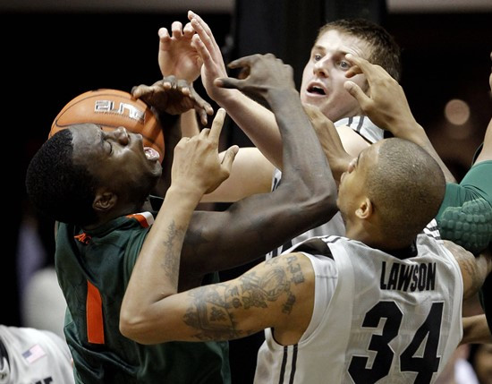 Miami guard Durand Scott, left, gets tangled up with Purdue forward Jacob Lawson and guard Ryne Smith as the fight for a rebound.  (AP Photo/Michael...