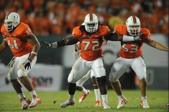 University of Miami Hurricanes offensive lineman Joel Fiqueroa #61, Tyler Horn #63 and Brandon Washington #72 are set to block defenders in a game...