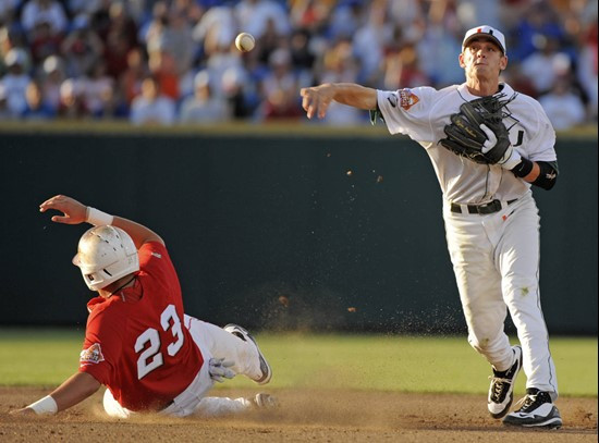 Miami shortstop Ryan Jackson, right, throws to first base for a double play after forcing out Georgia's Joey Lewis (23) in the fifth inning of an NCAA...