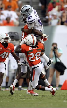 Miami's Andrew Swasey (28) and JoJo Nicolas (29) stop Kansas State's Sheldon Smith (87). Smith's gain was called back by a penalty. (AP Photo/J Pat...