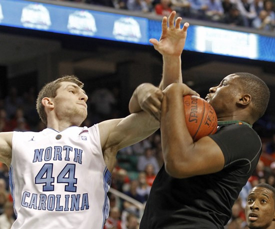 North Carolina's Tyler Zeller, left, and Miami's Reggie Johnson battle for a rebound in the first half of an NCAA college basketball game at the...