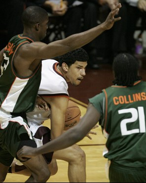 Virginia Tech's A.D. Vassallo looks to pass after penetrating the Miami defense of Brian Asbury, left, and Dwayne Collins (21) during the second half...