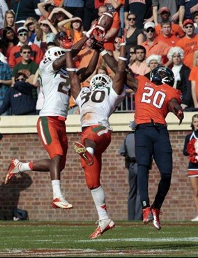 Miami defensive back Brandon McGee (21) hauls in an interception along with teammate defensive back A.J. Highsmith (30) in front of Virginia wide...