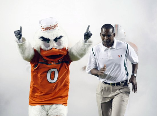 Randy Shannon runs alongside Sebastian the Ibis.