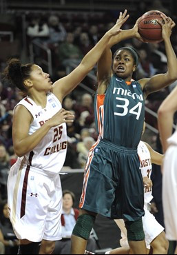 Miami's Sylvia Bullock (34) looks to pass over the reach of Boston College's Deidra Smith. (AP Photo/Gretchen Ertl)