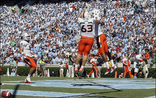 Miami's Tyler Horn (63), Tommy Streeter (8) and Chase Ford (9) celebrate Streeter's touchdown against North Carolina. (AP Photo/Gerry Broome)