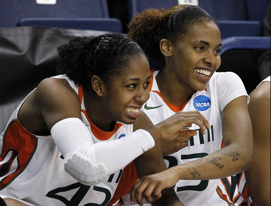 Miami's Shenise Johnson, left, and Suriya McGuire smile as they watch from the bench in the final moments of an NCAA tournament first-round women's...