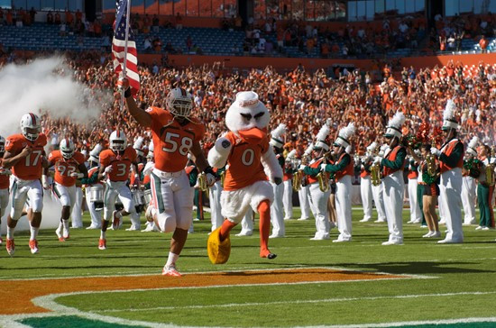 Sebastian the Ibis and linebacker Jordan Futch #58, lead the University of Miami Hurricanes through a tunnel of smoke in a game against the Georgia...