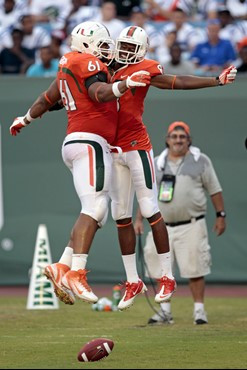 Miami's Tommy Streeter (8) and Joel Figueroa (61) celebrate Streeter's touchdown against Bethune-Cookman during the second half of an NCAA college...
