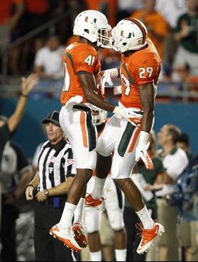 Miami defensive back JoJo Nicolas (29) celebrates with defensive back Mike Williams (41) after getting an interception during the second quarter of an...