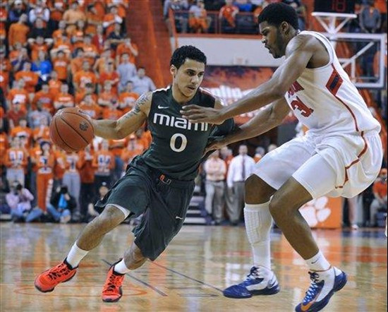 Miami's Shane Larkin (0) drives to the basket as Clemson's Devin Booker (31) defends in the second half of an NCAA college basketball game, Sunday,...