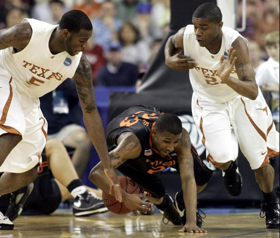 James Dews falls on the ball as Texas guard Damion James (5) and Texas guard Justin Mason (24) defend in the second half. (AP Photo/Sue Ogrocki)