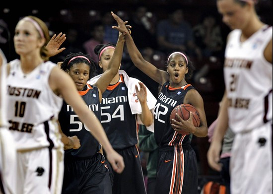 Miami's Shenise Johnson (42), Selina Archer (54) and Maria Brown, center left, celebrate Miami's 90-80 victory as Boston College's Kerri Shields (10)...