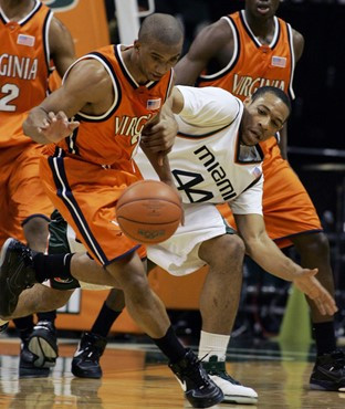 Virginia guard J.R. Reynolds, left, and Miami forward Keaton Copeland battle for a loose ball during the first half of basketball Wednesday, Feb. 21,...
