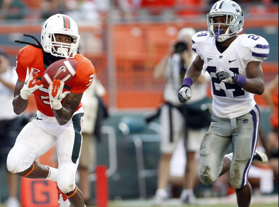 Miami wide receiver Travis Benjamin, left, pulls in a touchdown pass from quarterback Jacory Harris as Kansas State defensive back Nigel Malone...
