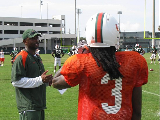 Coach McDonald speaks with wide receiver Travis Benjamin during a practice drill on Friday.