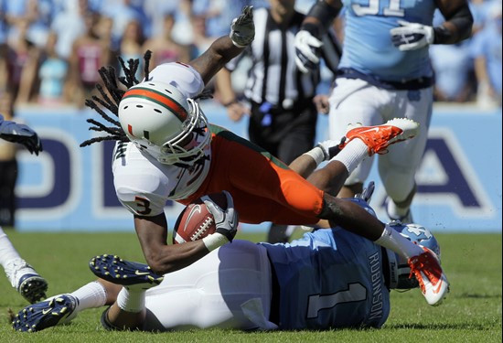Miami's Travis Benjamin (3) is tackled by North Carolina's Gene Robinson (1). (AP Photo/Gerry Broome)