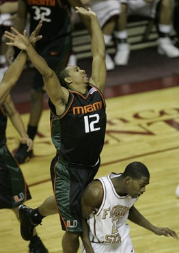 Miami's Anthony Harris (12) jumps on the back of Florida State's Toney Douglas after making a pass in the first half of a college basketball game,...