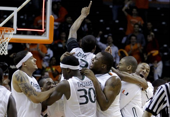 Miami guard James Dews, top center, celebrates with Adrian Thomas (30) and other teammates after making the game-winning basket against Georgia Tech...