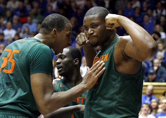 Miami's Kenny Kadji (35), Durand Scott, rear, and Reggie Johnson, right, react following a basket during the second half  of an NCAA college...