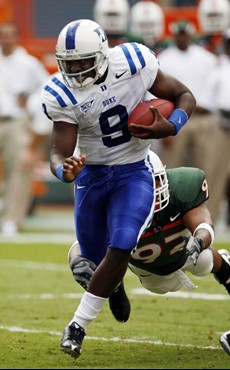 Duke quarterback Thaddeus Lewis (9) runs the ball as Miami (FL) defensive lineman Josh Holmes prepares to tackle during the first quarter of a college...