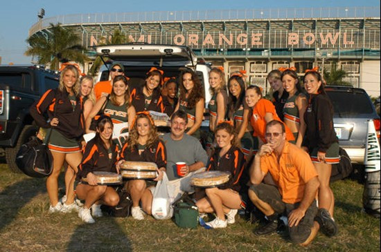 University of Miami cheerleaders pose for a photograph with fans before a game between the Miami Hurricanes and the Virginia Cavaliers at the Orange...