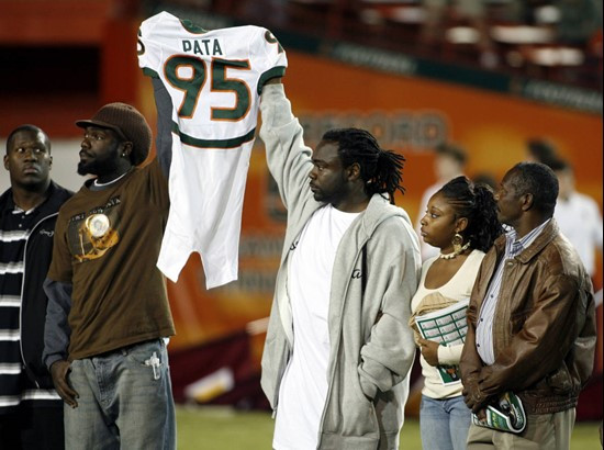 Bryan Pata's family hold up his jersey at the beginning of a college football game Miami and Boston College, Thursday, Nov. 23, 2006, at the Orange...