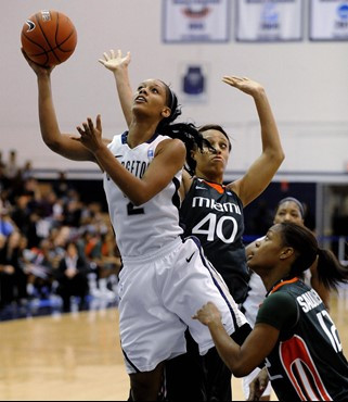 Georgetown's Tia Magee goes up for two points away from Miami defenders Shawnice Wilson (40) and Krystal Saunders, right, during second half of an...