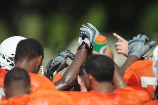 The 2010 Miami Hurricanes put their hands together in a sign of unity at Greentree Practice Field on August 13 in afternoon drills to prepare for the...