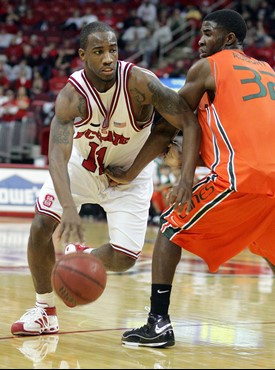 North Carolina State's Gavin Grant (11) drives the ball around Miami's Brian Asbury during the second half of a college basketball game in Raleigh,...