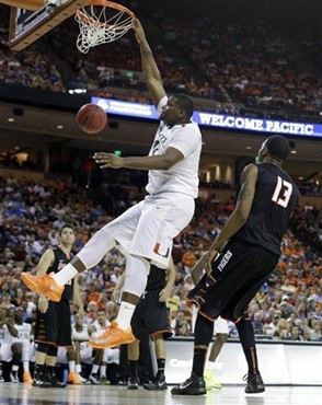 Miami's Reggie Johnson dunks over Pacific's Khalil Kelley (13) during the second half of a second-round game of the NCAA college basketball tournament...