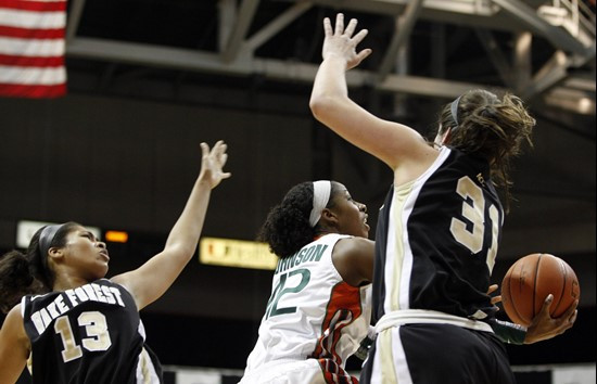 Miami's Shenise Johnson, center, shoots as Wake Forest's Mykala Walker (13) and Lindsy Wright defend. (AP Photo/Lynne Sladky)
