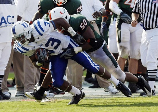 Duke running back Desmond Scott (33) is tackled by Miami linebacker Darryl Sharpton (50) during the fourth quarter of an NCAA college college football...