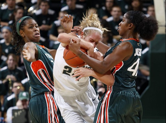 Miami's Sylvia Bullock, left, and Shenise Johnson, right, pressure Michigan State's Courtney Schiffauer, center, during the second half. (AP Photo/Al...