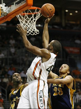 Miami's Raymond Hicks, center, goes up to score against the defense of North Carolina A&T's Julian McCurklin, left, and Thomas Coleman during the...