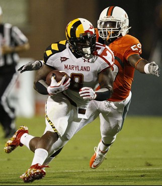 Maryland running back Davin Meggett (8) tries to outrun Miami linebacker James Gaines in the first half of an NCAA football game in College Park, Md.,...